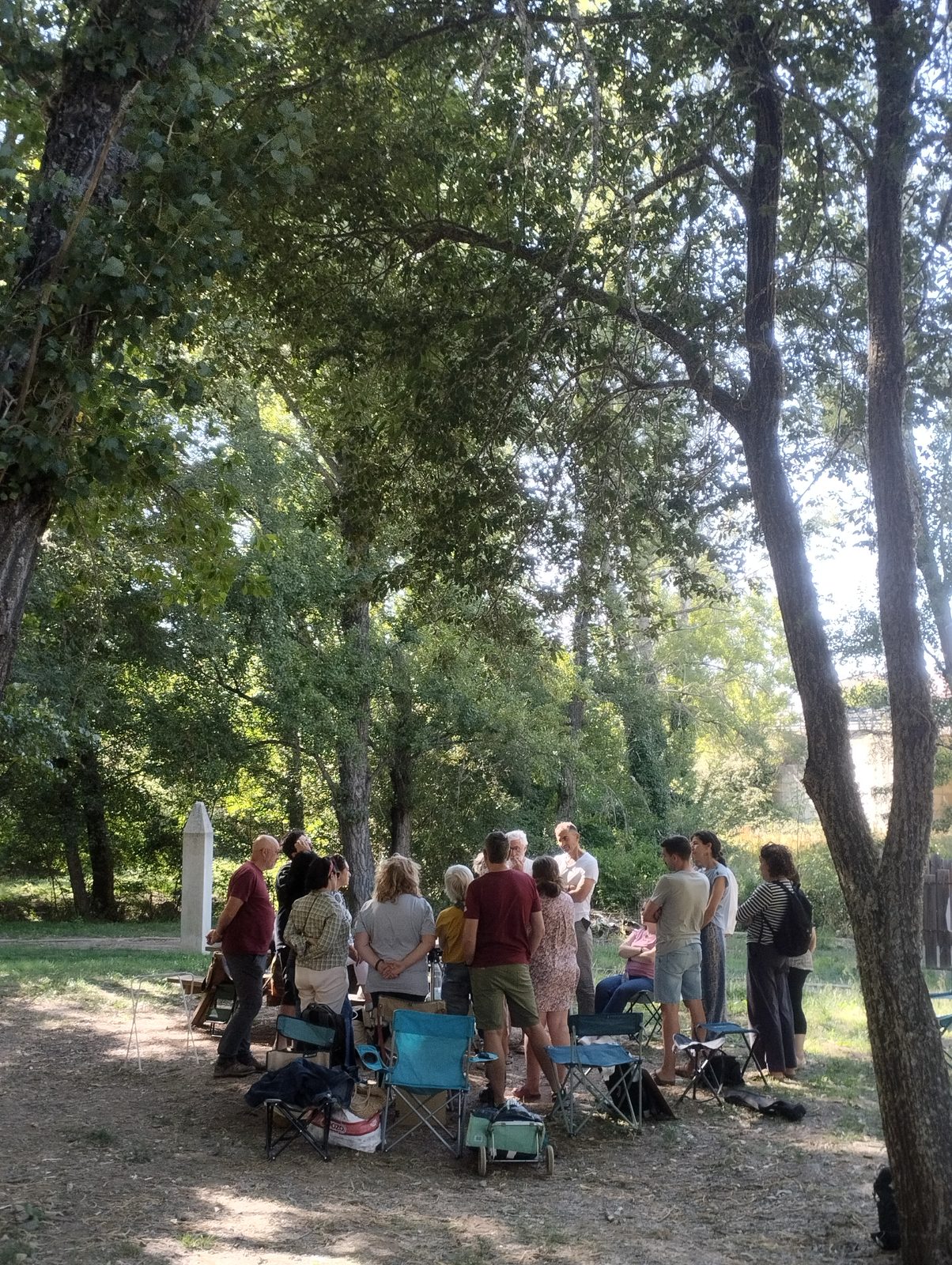 Grupo de participantes reunido bajo un árbol durante la edición XXXII