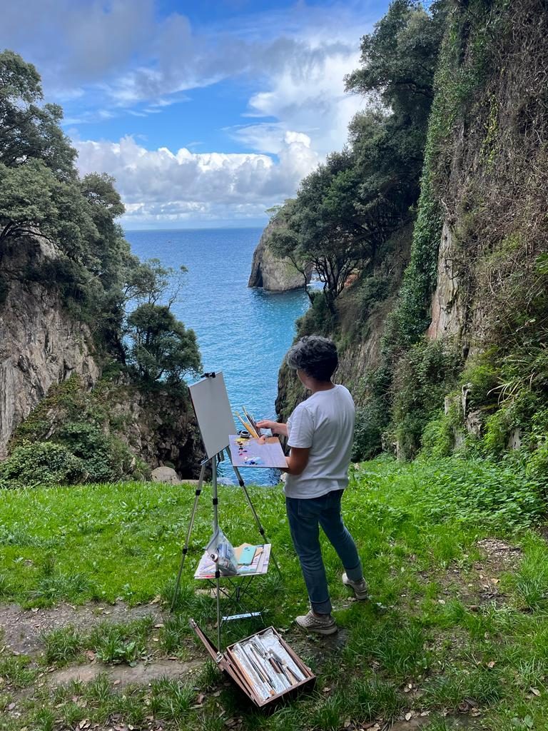 Gloria pintando un acantilado en la costa asturiana