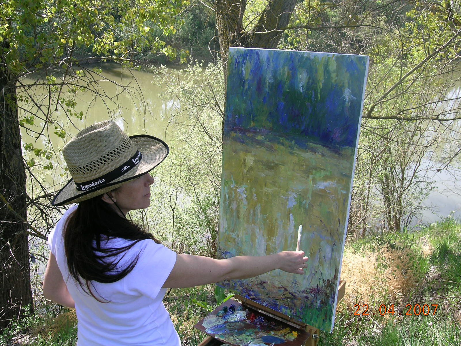 Gloria pintando un paisaje de río al óleo en 2007